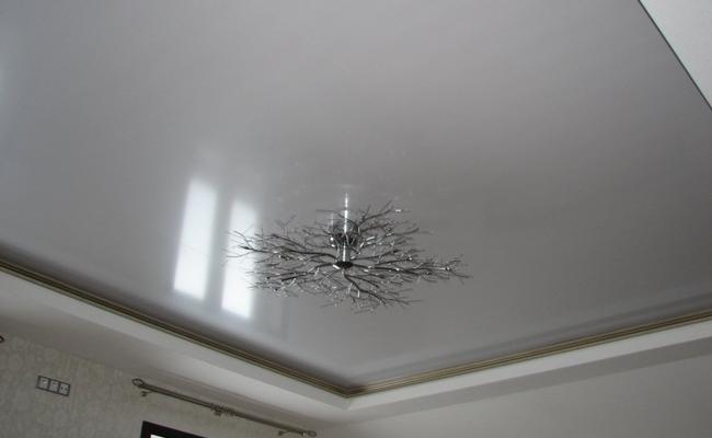 Бело серый глянцевый потолок в спальню
