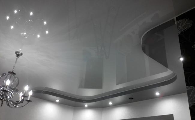 Серый натяжной глянцевый потолок в спальню