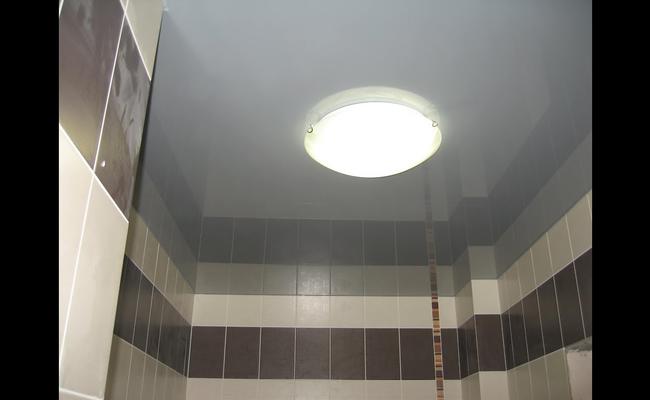 Серый натяжной глянцевый потолок в ванную